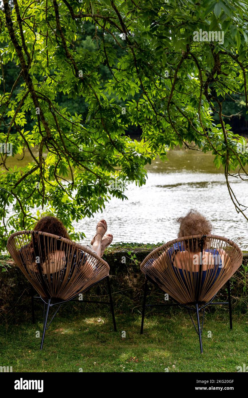 Women relaxing by a river in in western France Stock Photo