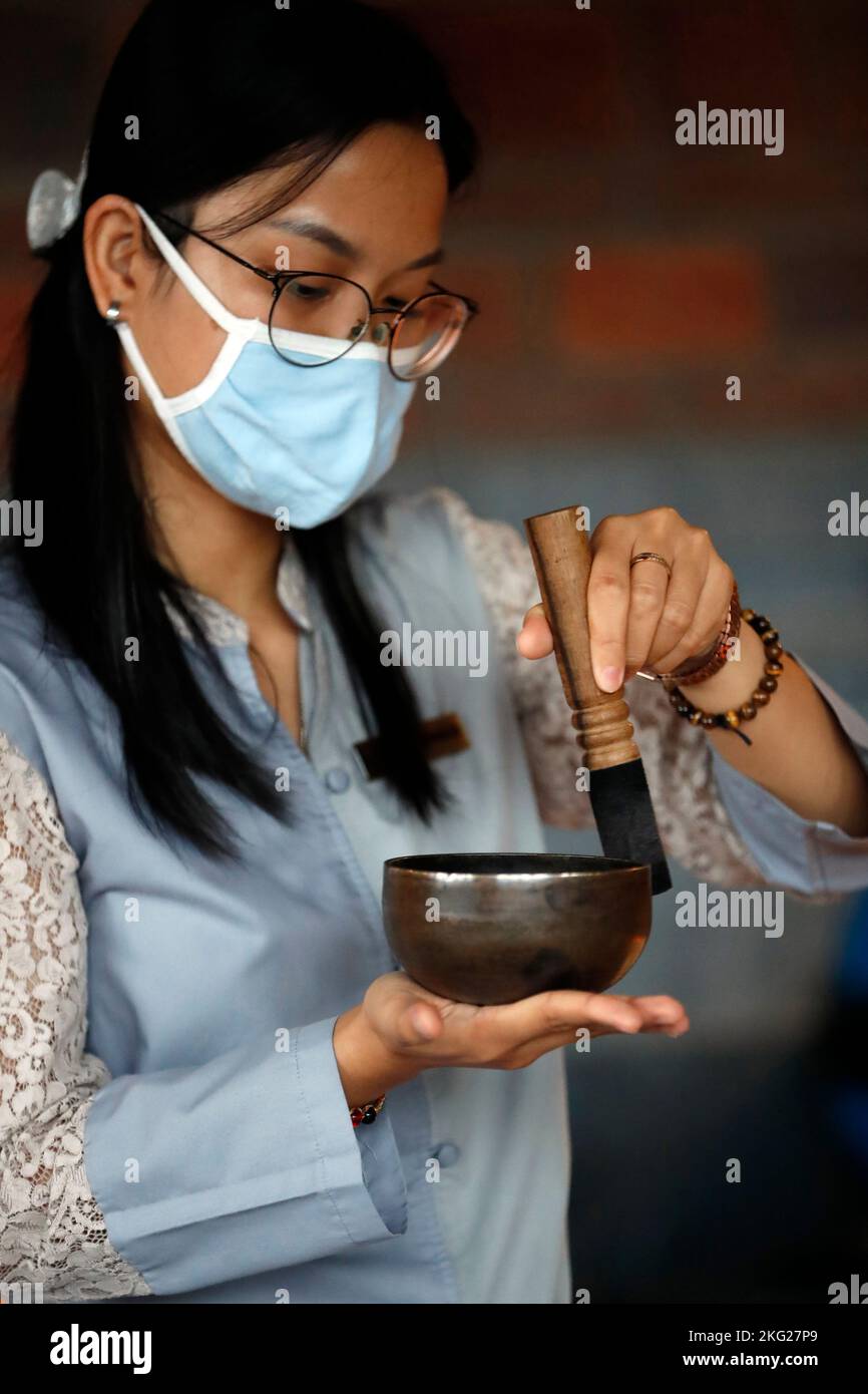 Woman using a tibetan singing bowl. Self care, meditation, recreation
