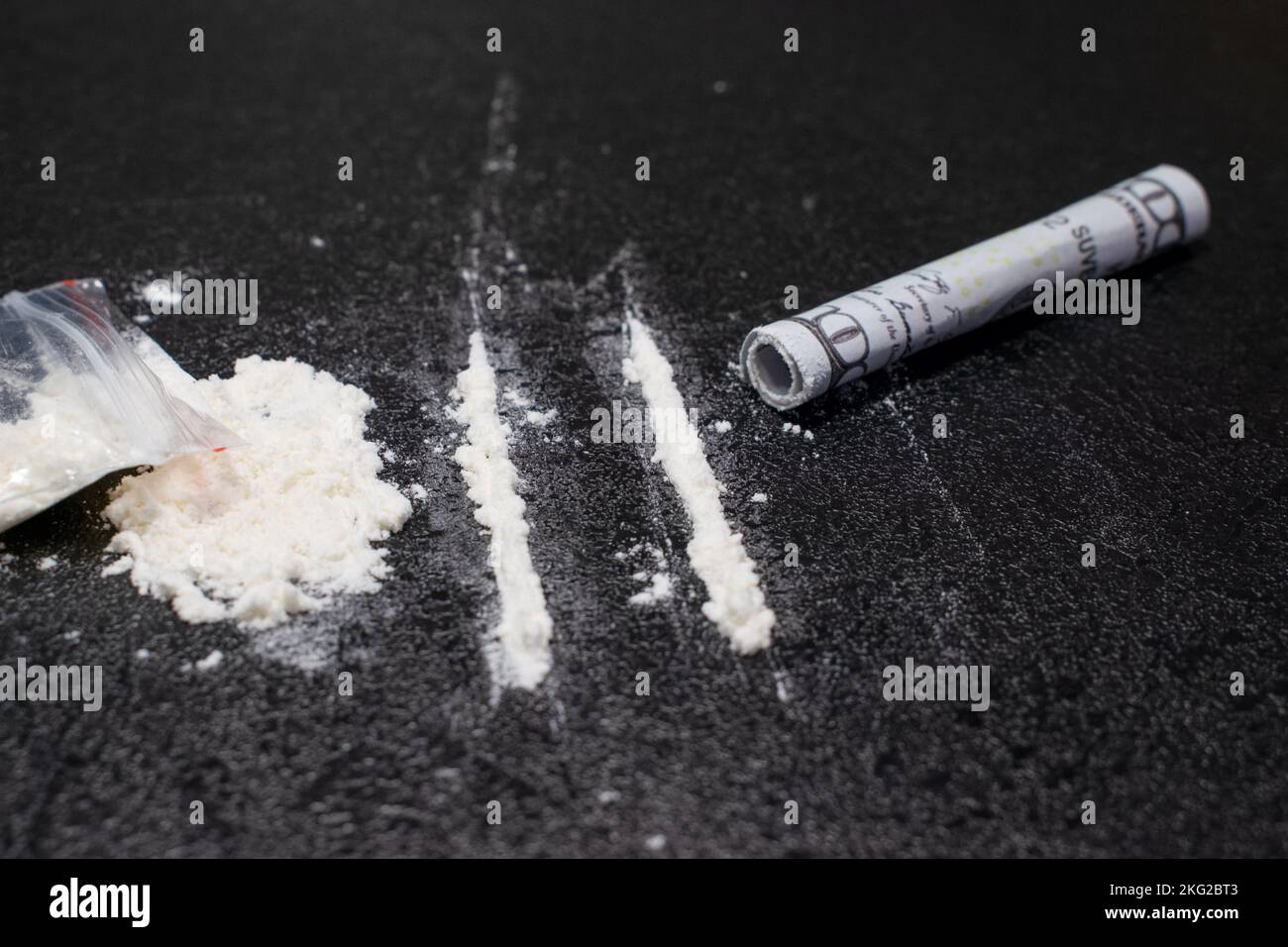 https://c8.alamy.com/comp/2KG2BT3/plastic-bag-two-lines-and-a-bunch-of-cocaine-with-a-breathing-tube-with-hundred-dollar-bill-on-a-black-background-closeup-2KG2BT3.jpg