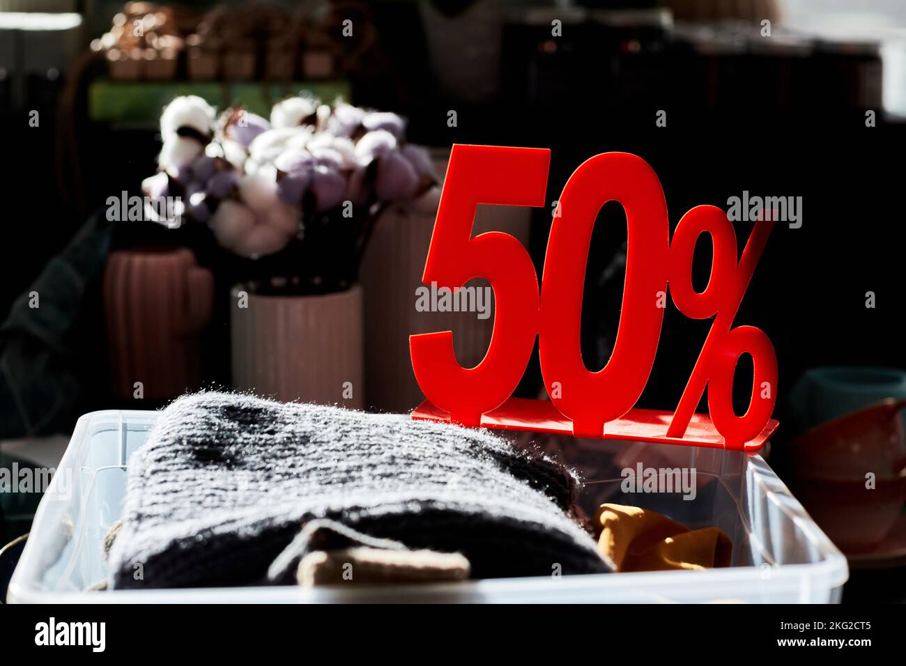 Close up of clothes bin in second hand store with 50 percent off red