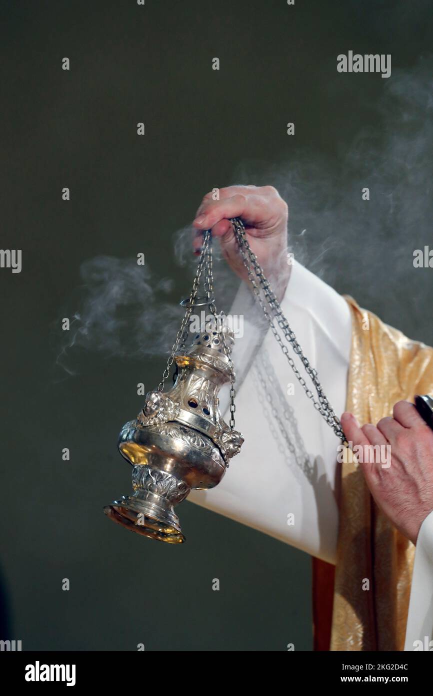 Catholic church. shaking a censer to produce smoke and fragrance