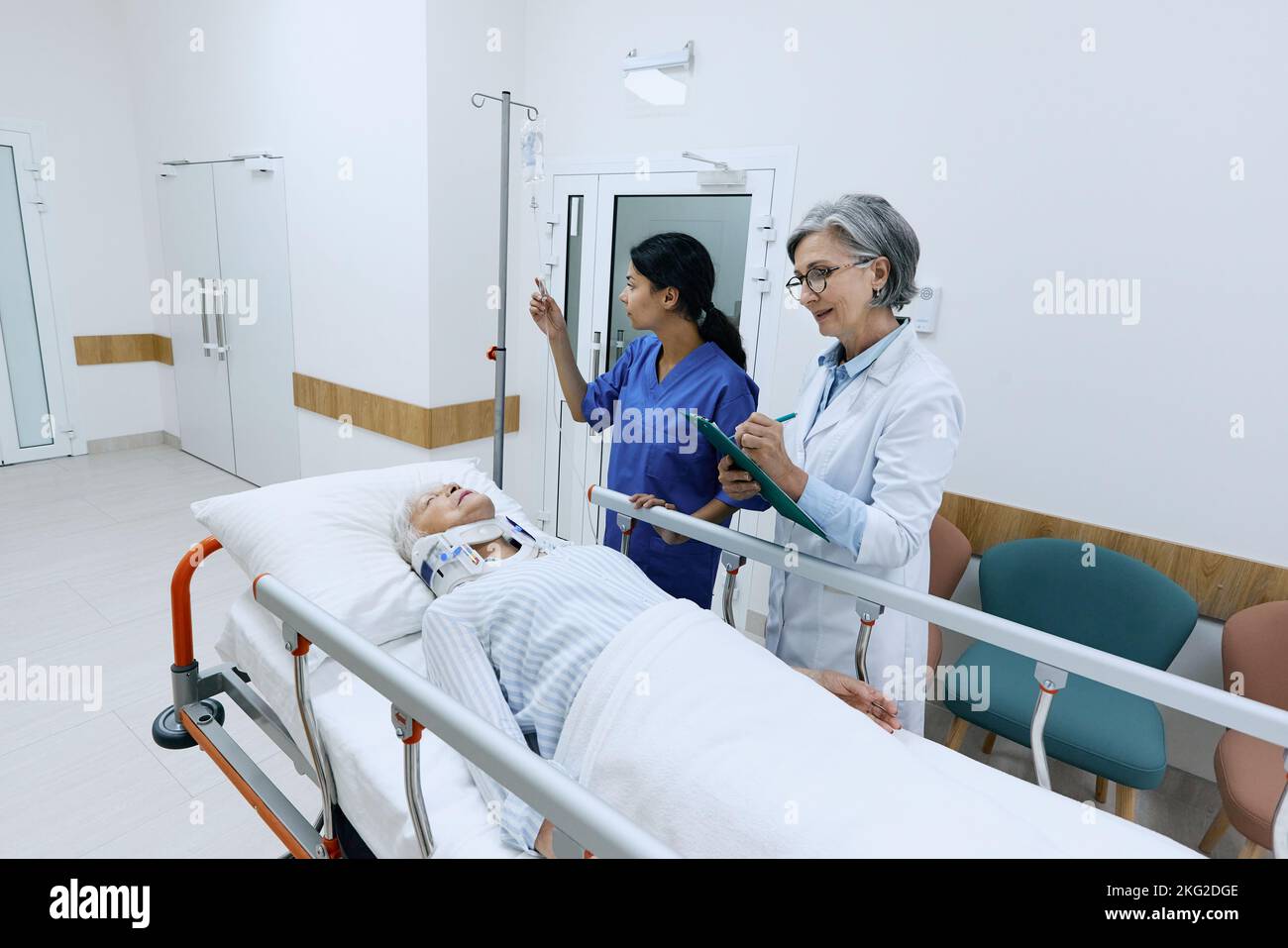 Doctor examining elderly patient with neck injury lying on medical