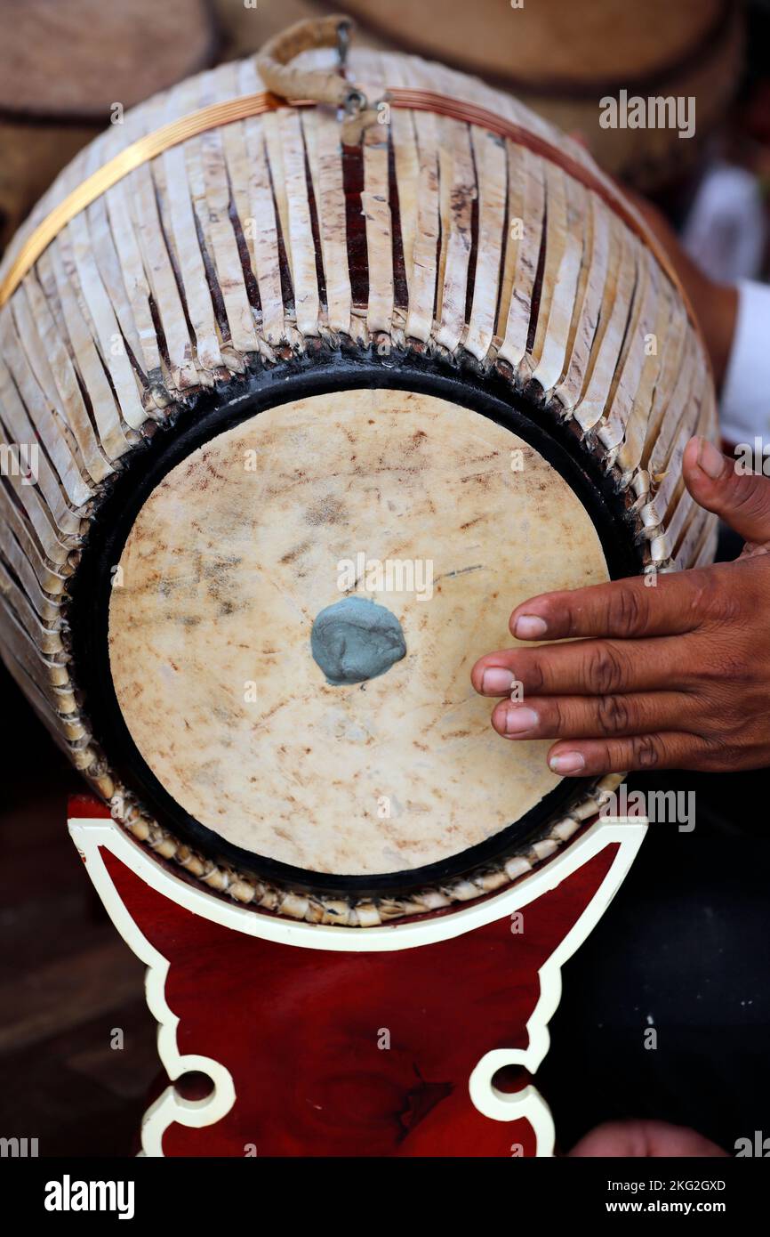 Traditional Khmer music. Cambodian man playing drums in pagoda. Phnom