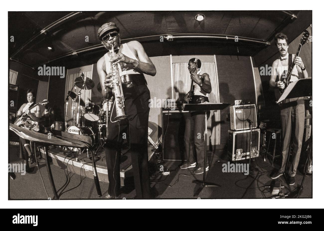 A 1986 fisheye lens photo of jazz saxophonist Julius Hemphill playing his soprano saxophone at a showcase for industry people. In a Manhattan studio. With bill Frisell on guitar. Stock Photo