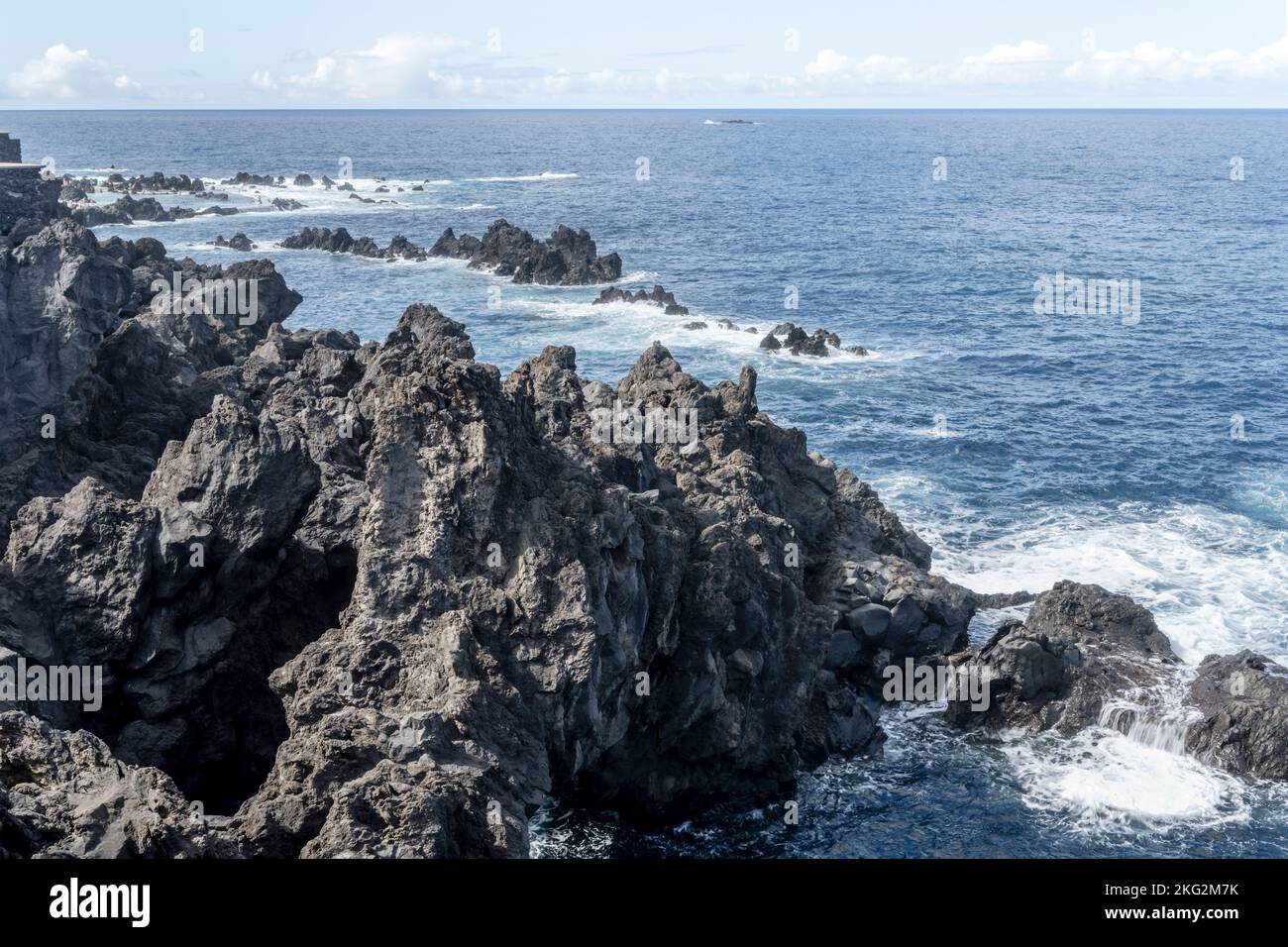 landscape with ocean waves dashing on volcanic shore at Madeira island, shot in bright fall light at Porto Moniz, Portugal Stock Photo