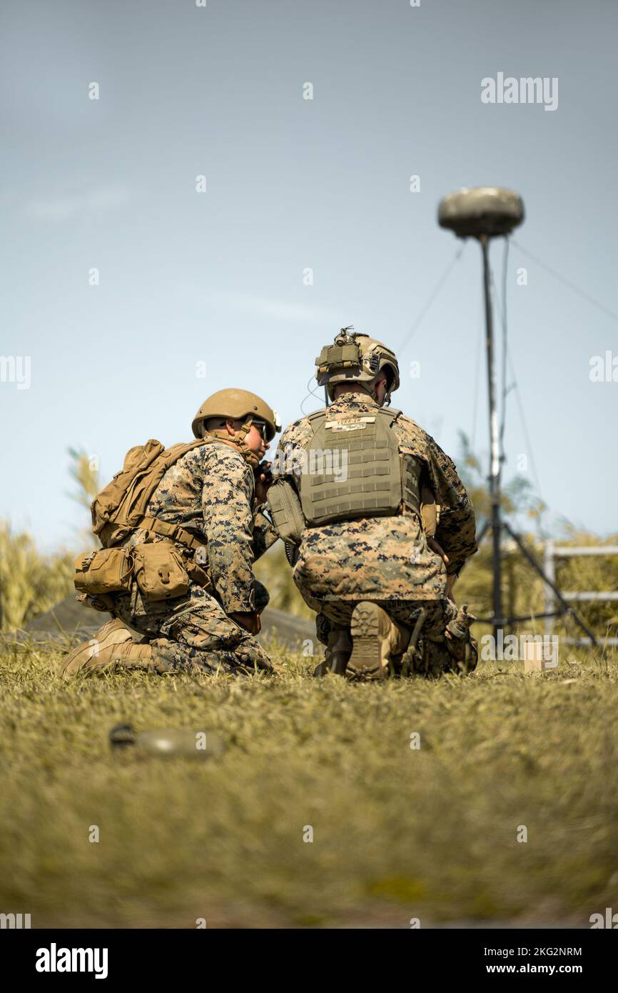 U.S. Marine Corps Lance Cpl. Julio Tinocodominguez, a digital wideband transmission equipment operator and Sgt. Zachary Verrier, a transmissions systems operator assigned to 5th Air Naval Gunfire Liaison Company, III Marine Expeditionary Force Information Group, conduct joint-coalition long range communication during exercise Katana Strike on Kumejima, Okinawa, Japan, Oct. 26, 2022. Katana Strike is led by III Marine Expeditionary Force Information Group and is designed to demonstrate proficiency in coalition joint-force planning, coordination, and execution of dynamic targeting in a maritime Stock Photo