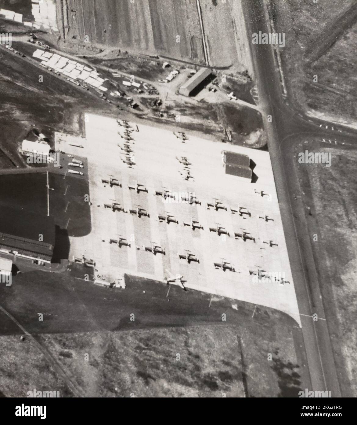 An aerial view of the Portland Air Force Base, Oregon Air National Guard Apron, home of the 142nd Fighter Group (Air Defense) circa 1962.  Present are 25 F-89J Scorpions (at least three appear to be painted in “ADC gray”), four T-33A jet trainers and one VC-47 transport.  Two single-aircraft alert shelters are seen at the upper right portion of the ramp, likely with alert F-89Js in them.  The long building at the top of the photograph is an Oregon Army National Guard aviation facility, soon to be removed as the Reserve Apron construction was completed.  (142nd Wing History Archive) Stock Photo