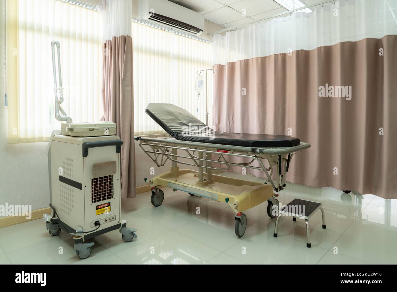 Sterile recovery room equipped with comfortable modern medical sickbed for patient recovery. Photo of a hospital bedroom or ward for patient treatment Stock Photo