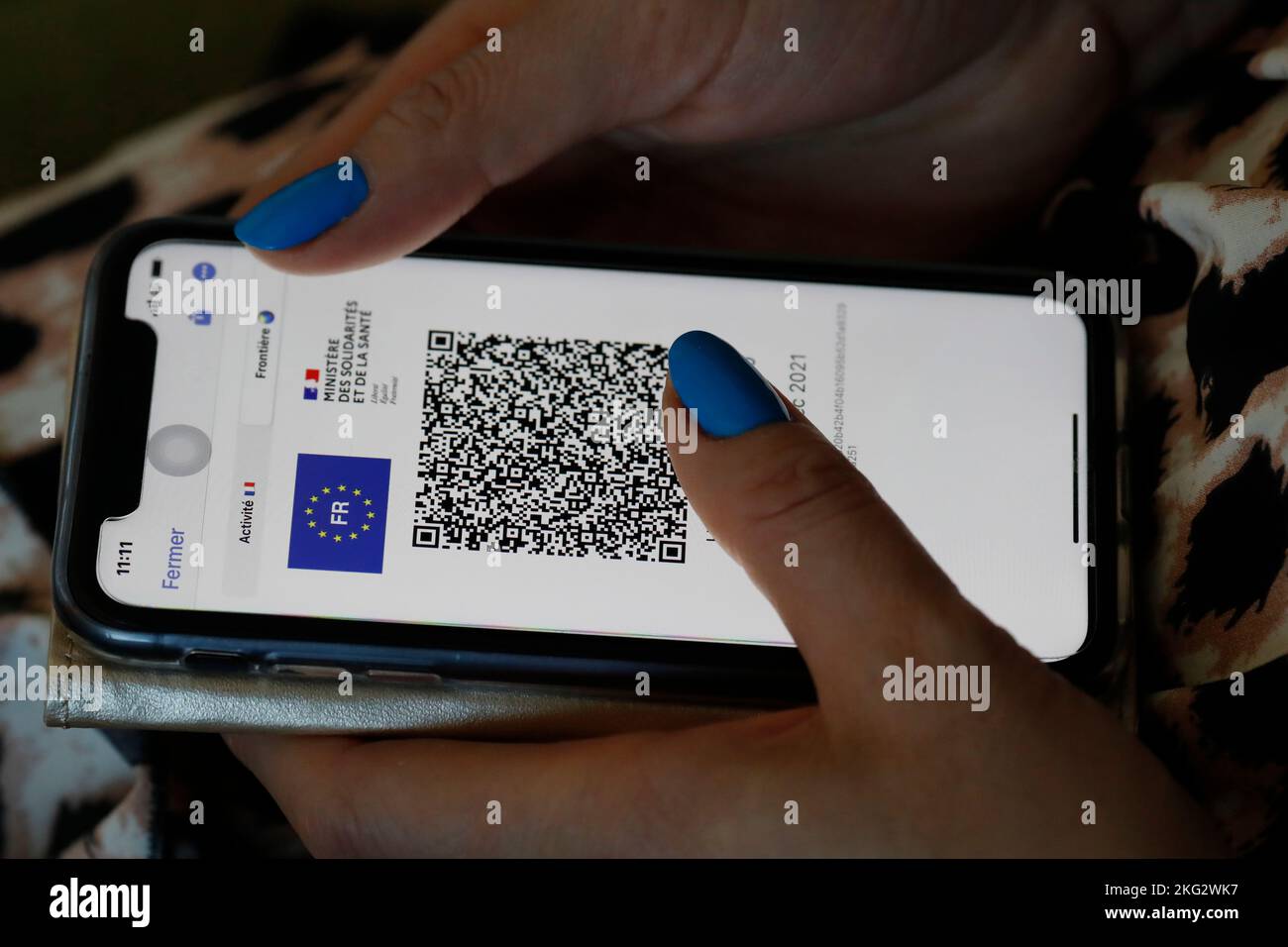 Woman looking a Covid pass with QR code on a smartphone. Close up on hands. Stock Photo