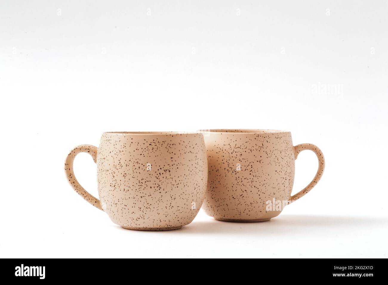 Empty beige coffee ceramic cups on isolated white background, cut out. Stock Photo