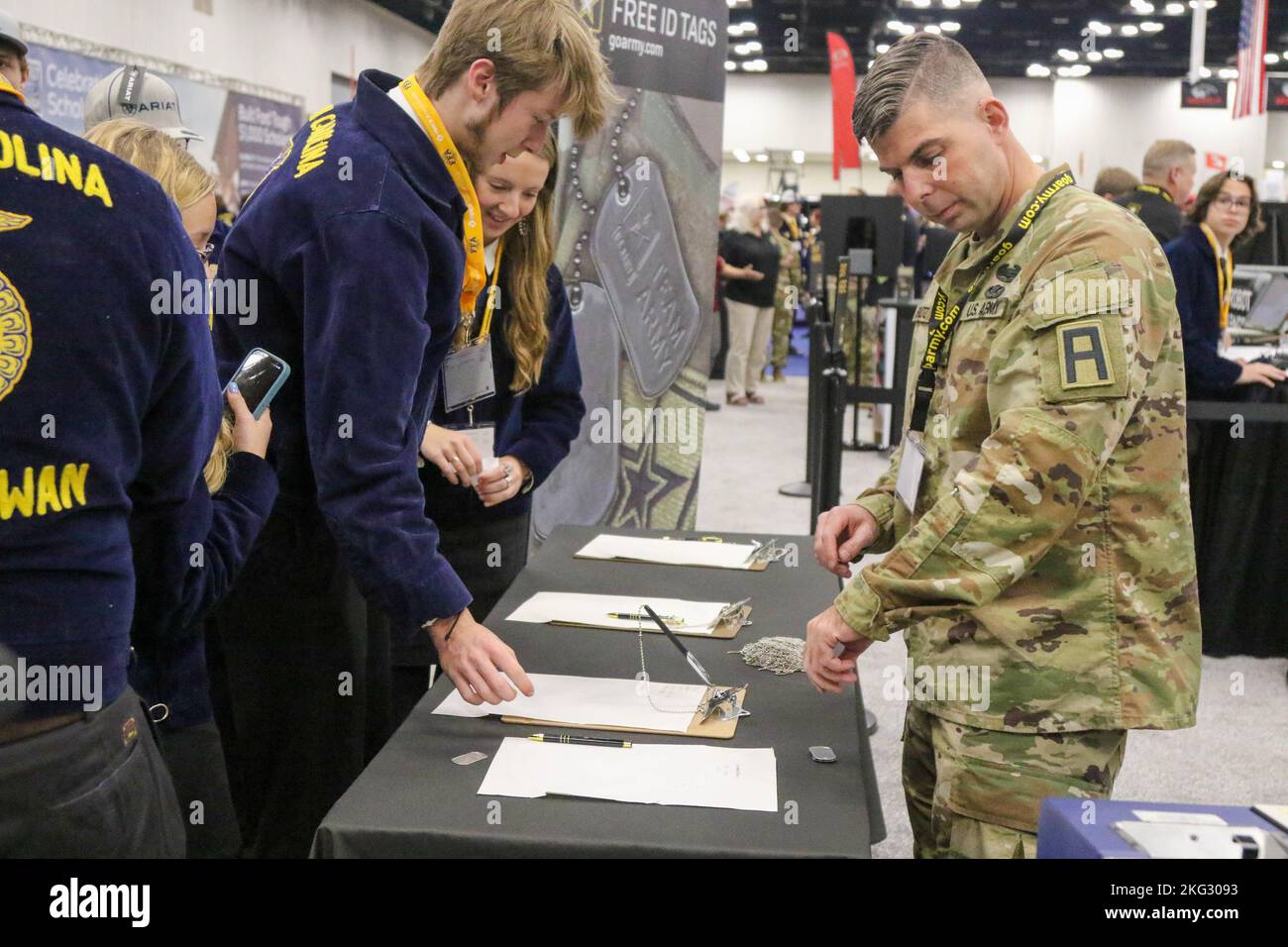 U.S. Army Sgt. 1st Class Justin Shultz, an observer coach/trainer assigned to 157th Infantry Brigade, First Army Division East, creates personalized military dog tags for a student during the 95th Annual Future Farmers of America Expo at the Indianapolis Convention Center, Indianapolis, IN Oct 26, 2022.157th Infantry Brigade represented the Army as the only active-duty unit in Indiana. Stock Photo