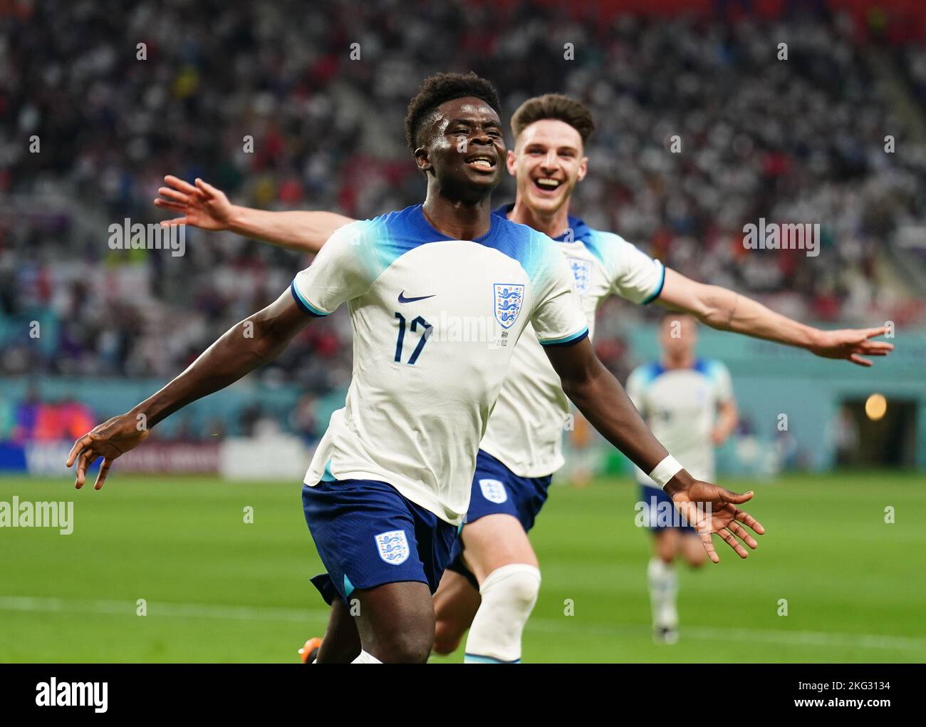 England's Bukayo Saka (left) celebrates scoring their side's second goal of the game during the FIFA World Cup Group B match at the Khalifa International Stadium, Doha. Picture date: Monday November 21, 2022. Stock Photo
