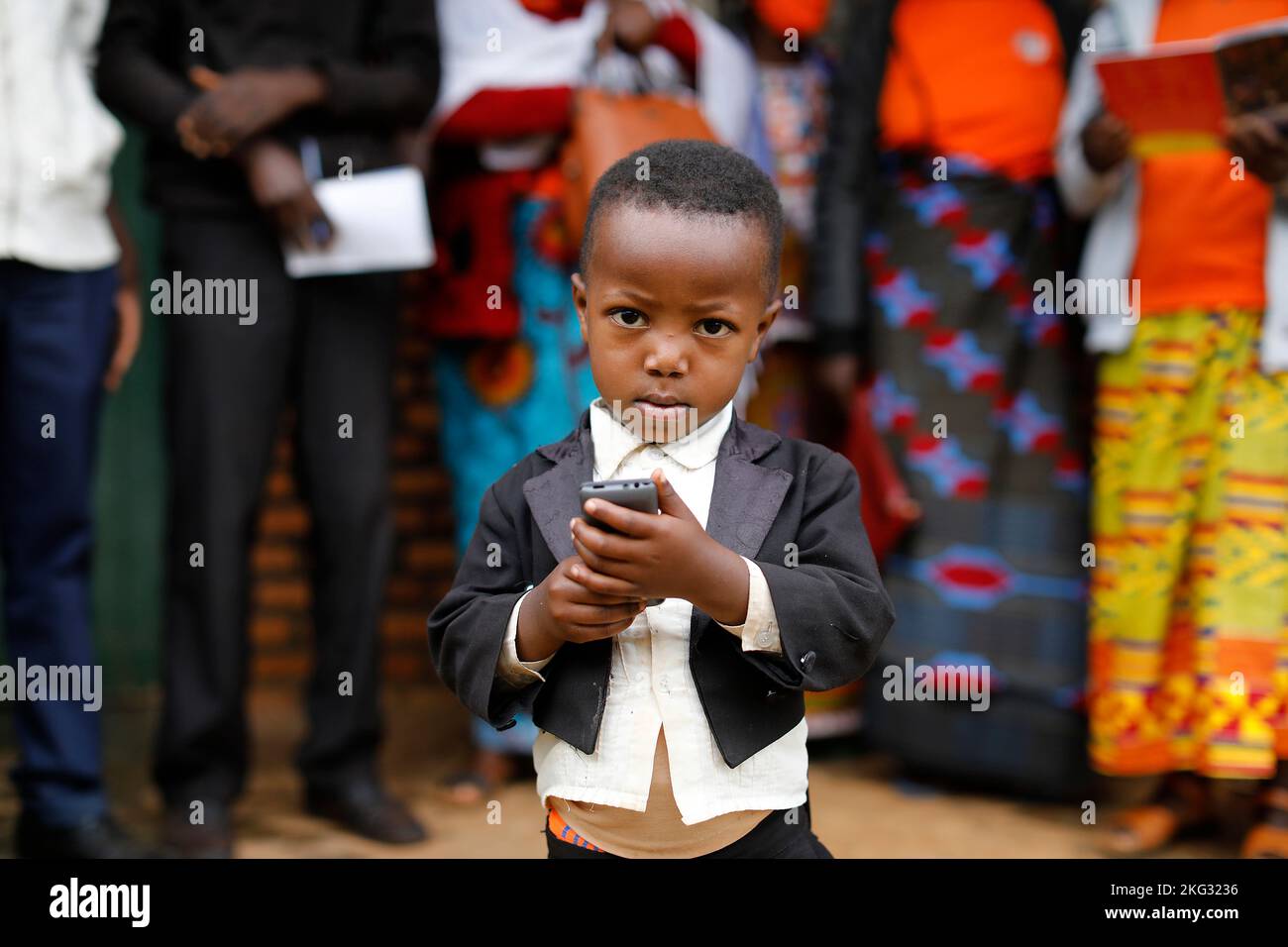 Meeting of Kolping members in Bungwe, Rwanda. Kolping is a christian German NGO. Boy holding a cell phone Stock Photo