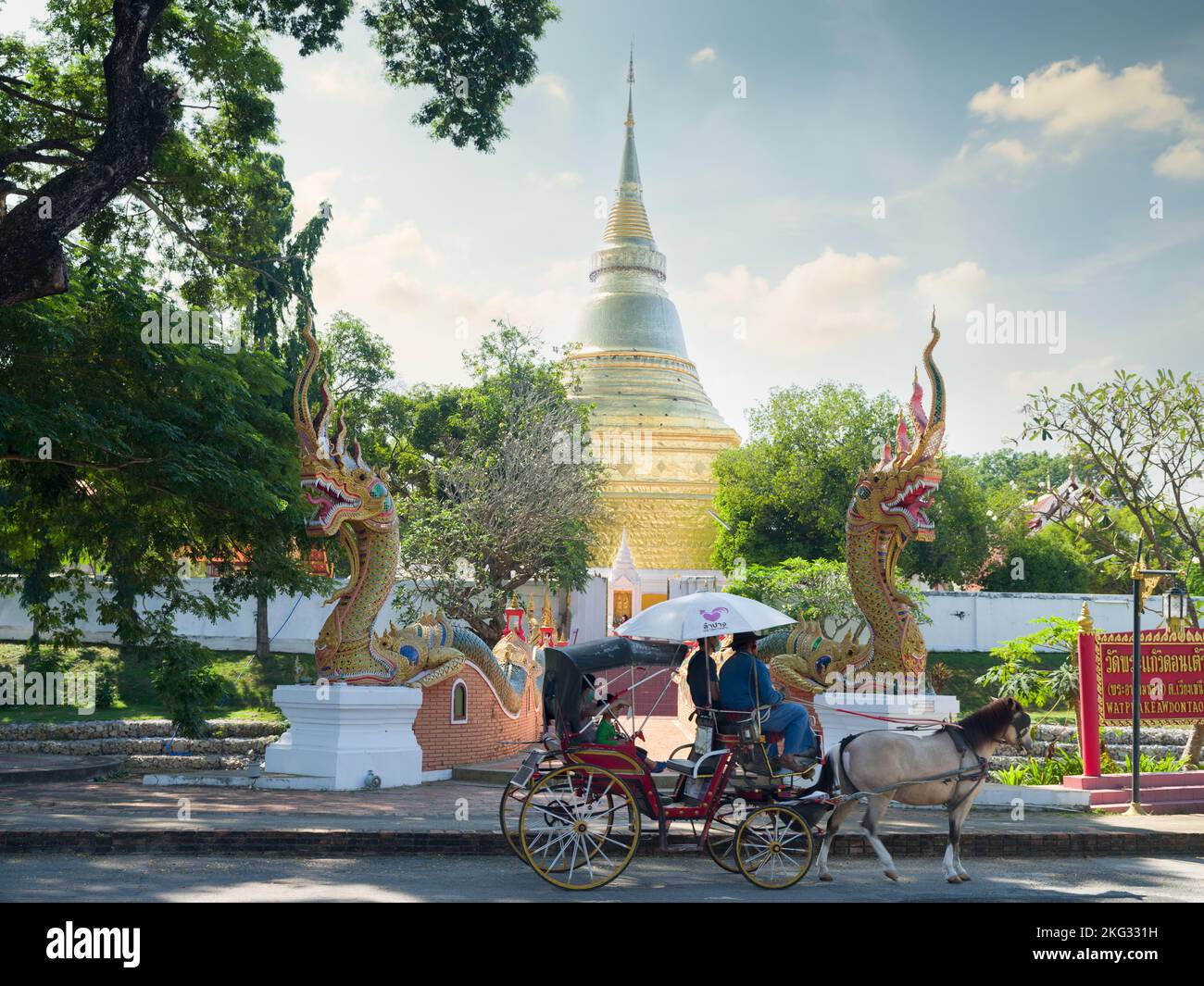Lampang city, Thailand. November 21, 2022. Wat Kaew Don Tao Suchadaram Temple. Tourists riding a traditional horse-drawn carriage at the temple Stock Photo