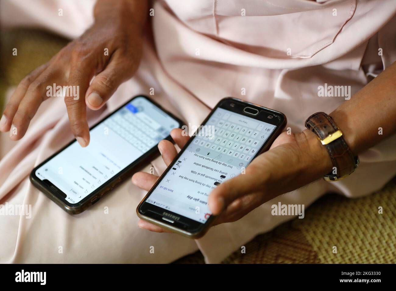 Man using two smartphones. Internet, game, Instagram and Faced Book. Close-up on hands.  Vietnam. Stock Photo
