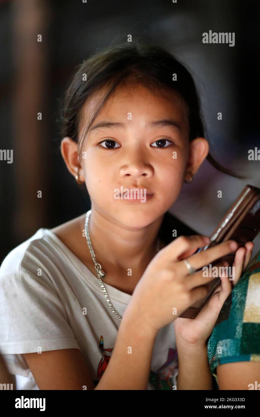 Asian girl using a smartphone. Internet, game, Instagram and Faced Book.  Tan Chau. Vietnam. Stock Photo