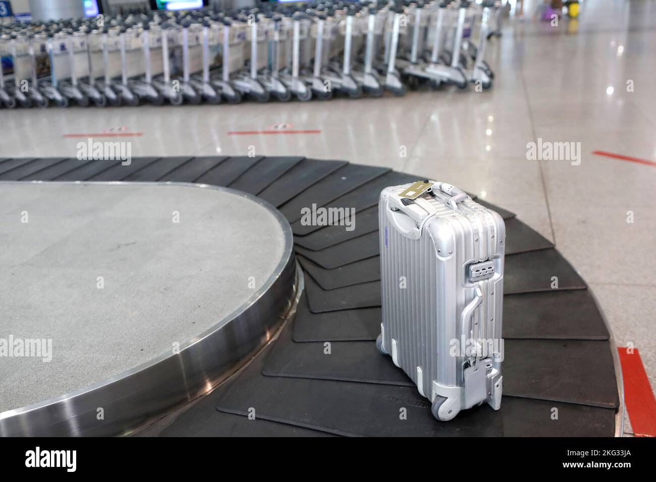 Checkered suitcase on an airport luggage carousel. Lost luggage