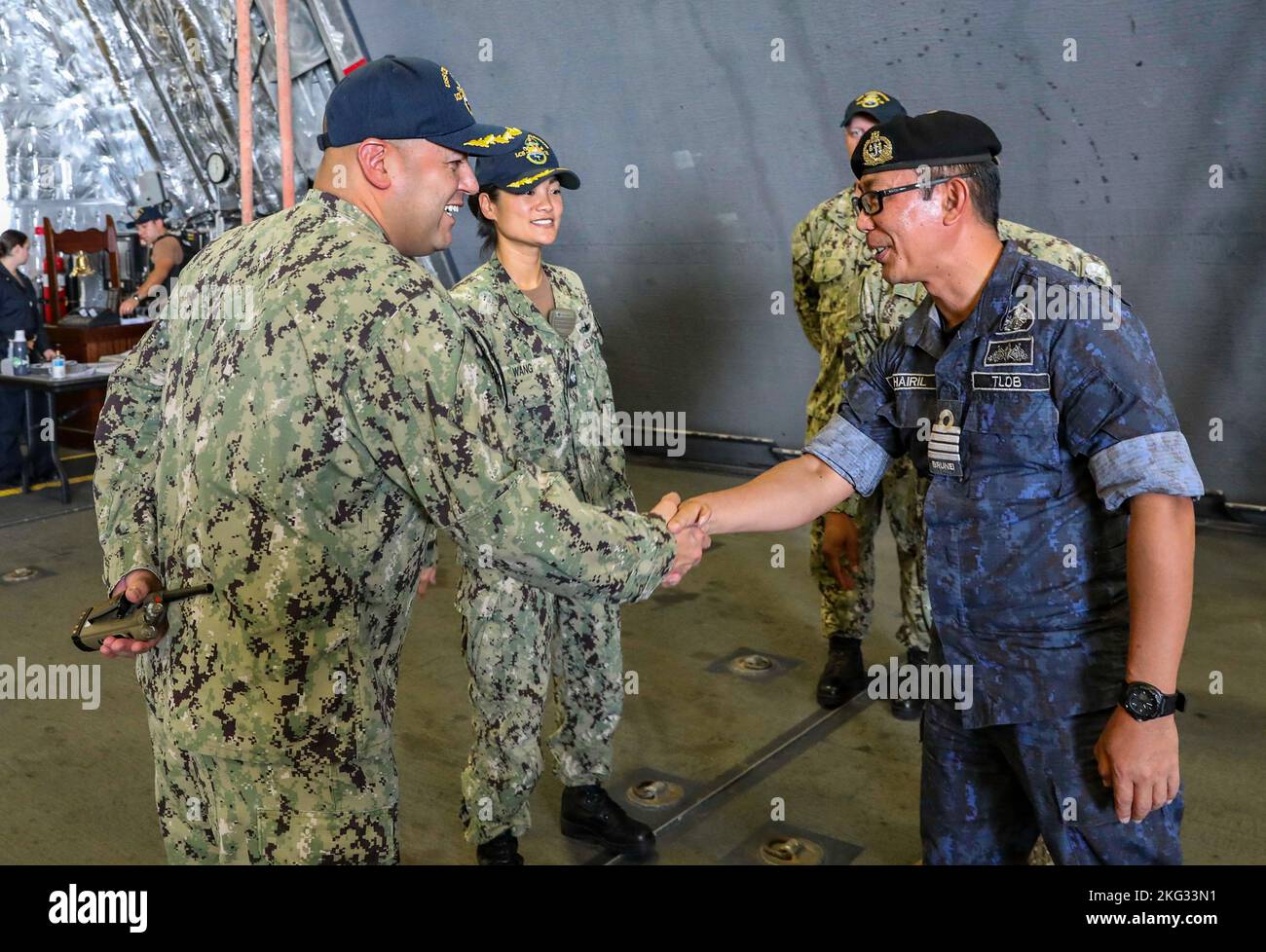 221026-N-FO714-1006  MUARA, Brunei (Oct. 26, 2022) Cmdr. Clayton Beas, commanding officer of Independence-class littoral combat ship USS Charleston (LCS 18), and Cmdr. Nellie Wang, executive officer of Charleston, welcome Capt. Khairil bin Haji Abdul Rahman, fleet commander, Royal Brunei Navy, aboard the ship during Cooperation Afloat Readiness and Training (CARAT) Brunei, Oct. 26. CARAT Brunei 2022 highlights the 28th anniversary of CARAT among Allies and partners as a way to demonstrate long-term commitment to strengthening relationships throughout South and Southeast Asia and to highlight U Stock Photo