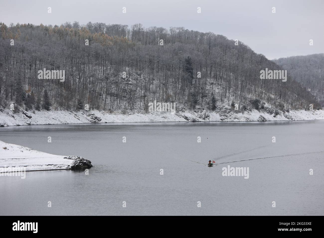 21 November 2022, Saxony-Anhalt, Thale: Two professional fishermen sail across the Rappbode Dam in a boat. They set their nets to fish the dwarf whitefish out of the lake. The small fish was used in the 1960s, as potential food for the large predatory fish. The reproductive power of the dwarf whitefish was underestimated at the time. It is estimated that dwarf whitefish now make up about 95 percent of the biological fish mass in the reservoir. In the long run, this could become a threat to water quality. Therefore, about 3 tons of the lesser whitefish are fished out of the lake every year. Pho Stock Photo