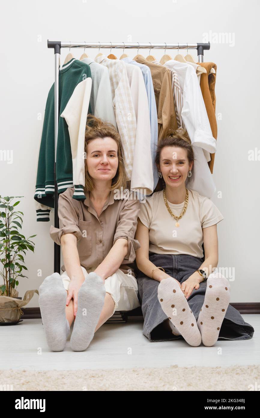 Wardrobe organization concept - two female friends sitting under ...