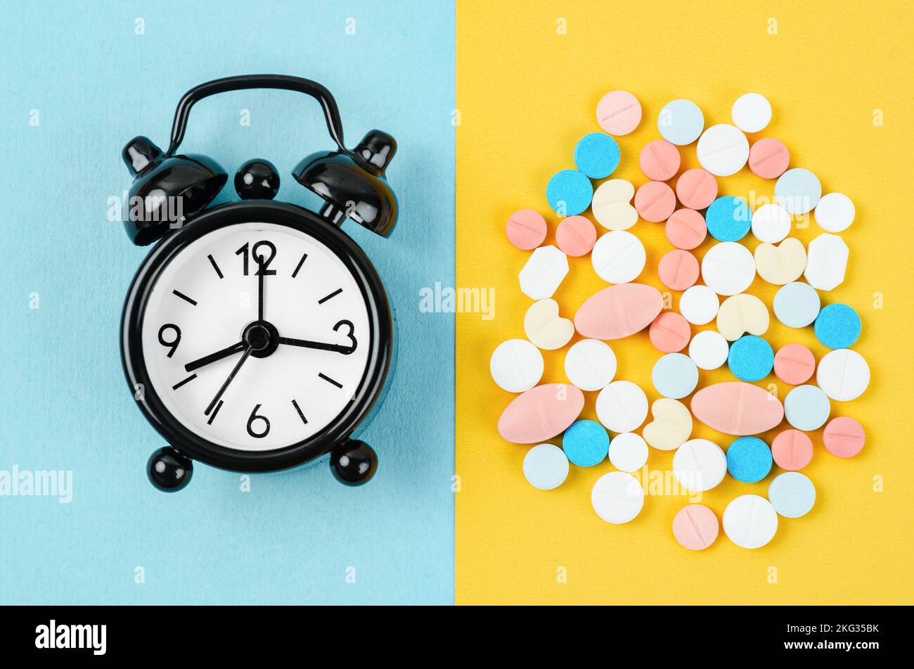 Alarm clock and many drug on a yellow background. Taking medicine at