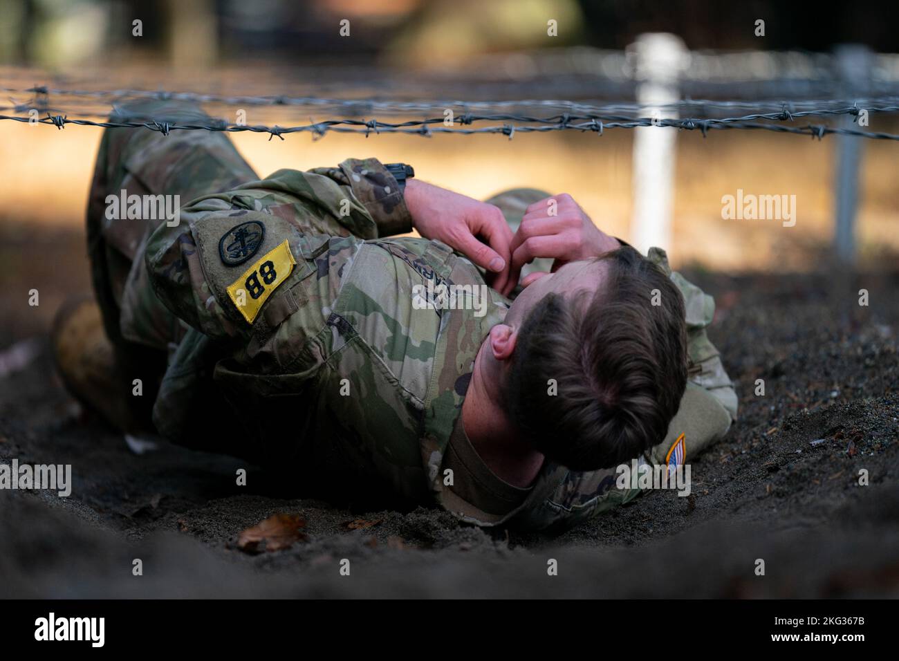 1st Lt. Austin Pinkerton from Bassett Army Medical Center, Fort Wainwright, crawls under the Low Wire during the Obstacle Course Test in the 2022 Medical Readiness Command, Pacific Best Medic Competition Wednesday, October 26th 2022 at Joint Base Lewis-McChord. Stock Photo