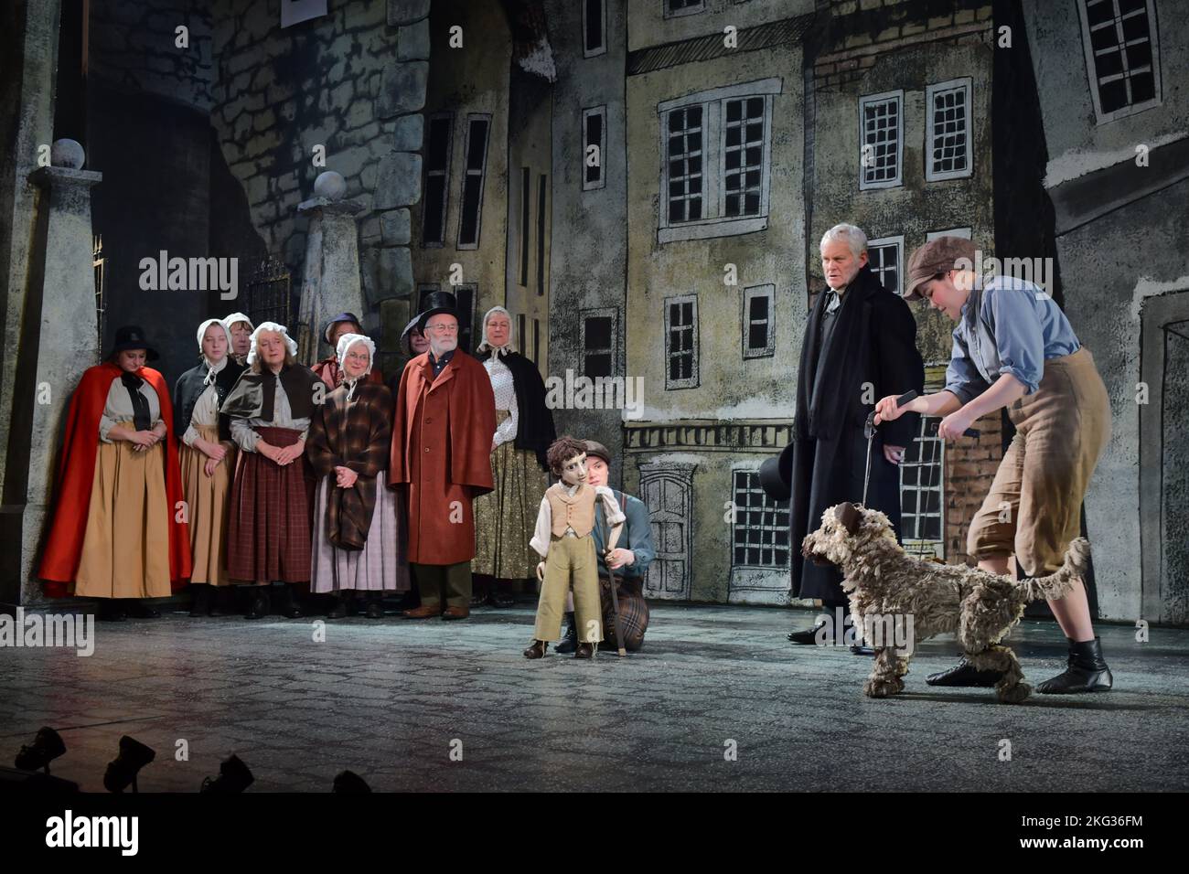 Edinburgh Scotland, UK 21 November 2022. Ebenezer Scrooge (Crawford Logan) and Greyfriars Bobby (puppeteer: Stacey Mitchell) and members of the production's community choir usher in the festival season on the stage set of An Edinburgh Christmas Carol at the Lyceum Theatre Edinburgh. credit sst/alamy live news Stock Photo