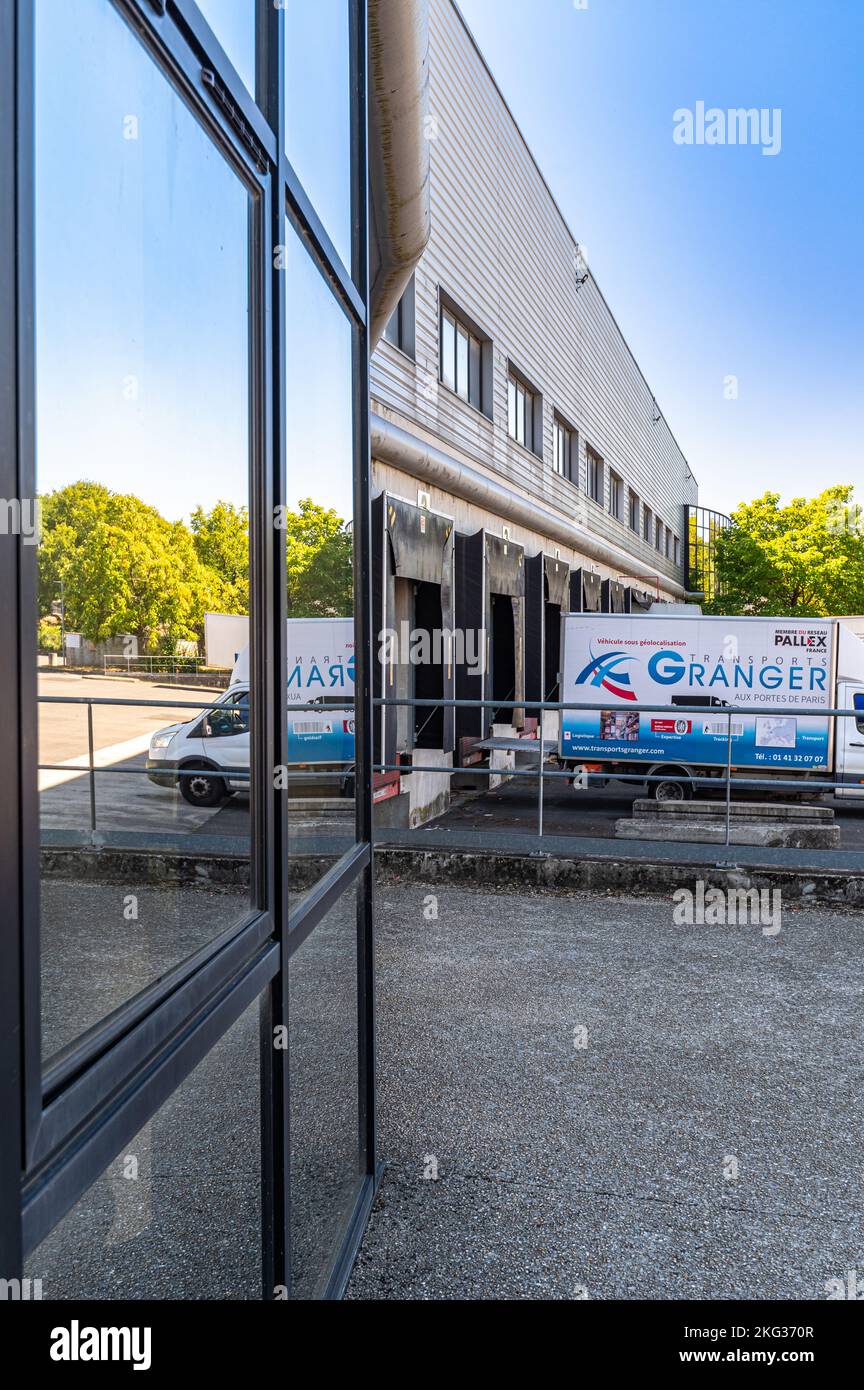 A vertical shot of commercial building featuring truck outside the loading dock Stock Photo