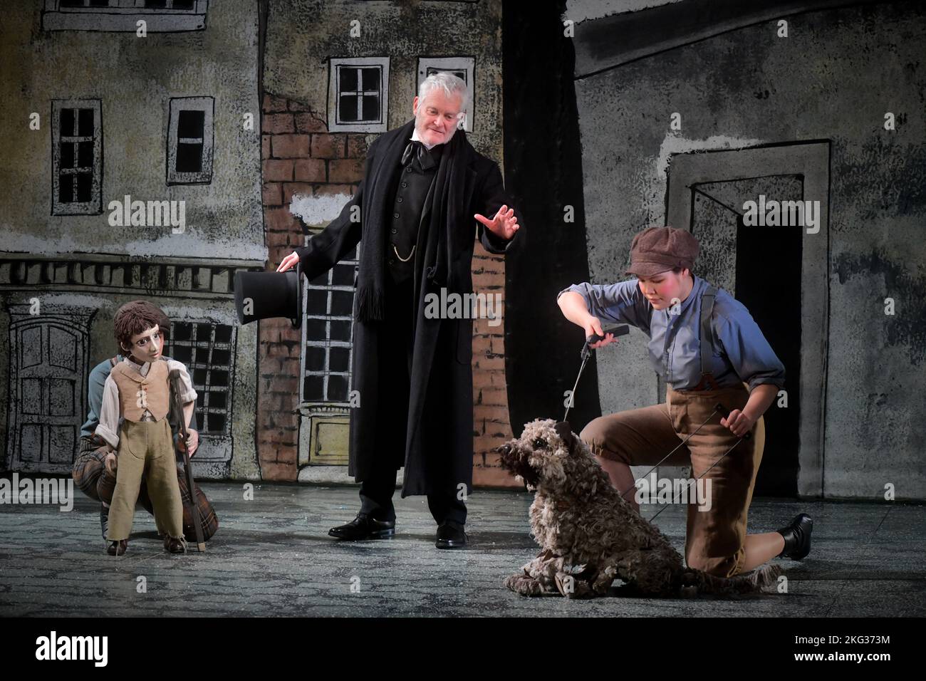 Edinburgh Scotland, UK 21 November 2022. Ebenezer Scrooge (Crawford Logan) and Greyfriars Bobby (puppeteer: Stacey Mitchell) and members of the production's community choir usher in the festival season on the stage set of An Edinburgh Christmas Carol at the Lyceum Theatre Edinburgh. credit sst/alamy live news Stock Photo