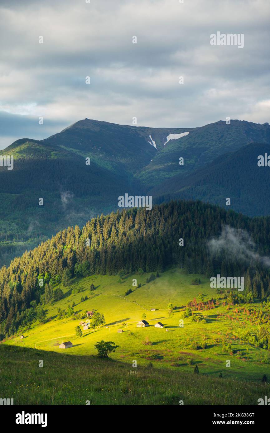 Mountain rural landscape with sun light on the green hills at sunrise Stock Photo