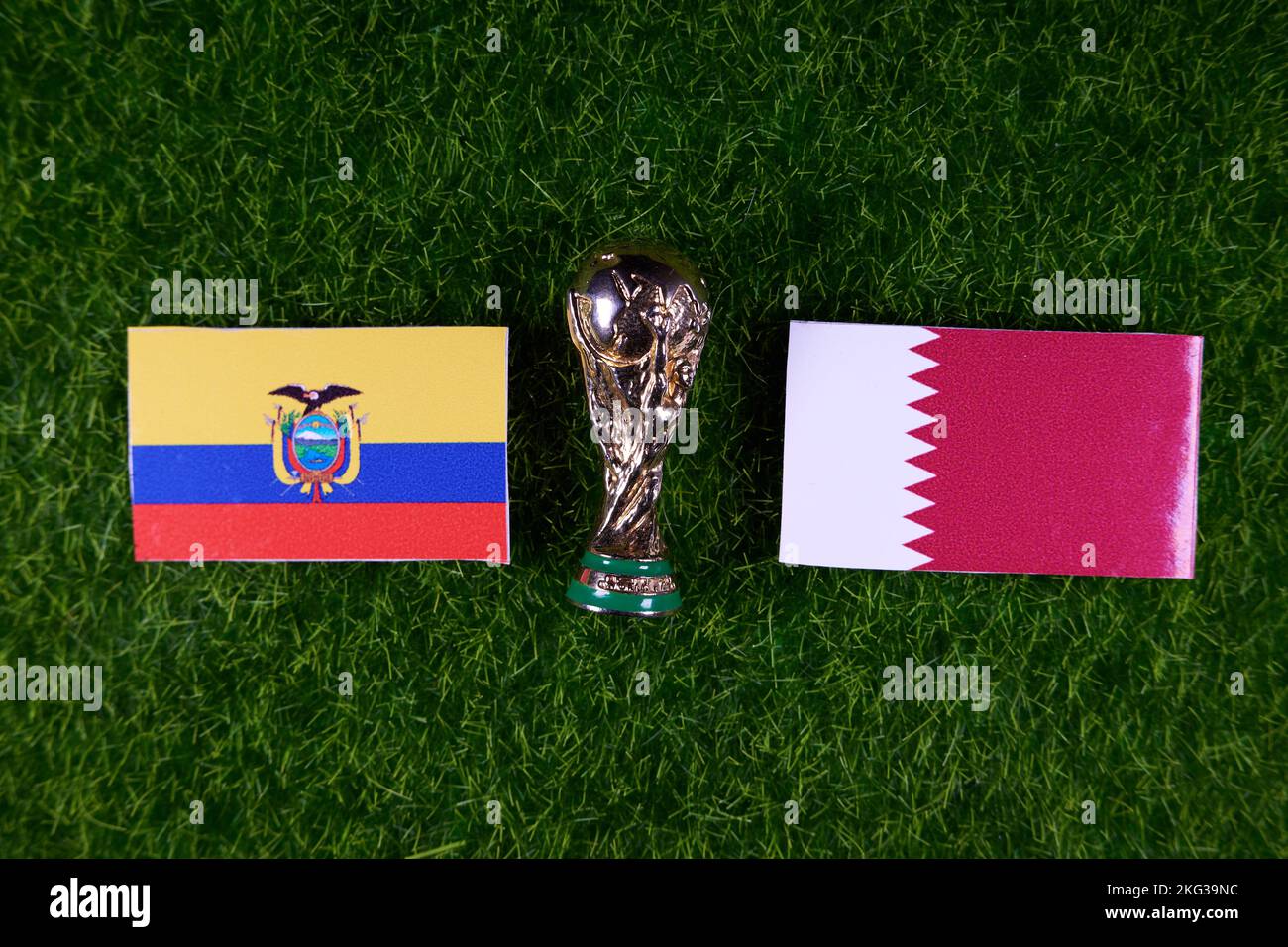 November 20, 2022, Doha, Qatar. Flags of Qatar and Ecuador and the FIFA World Cup trophy on the green lawn of the stadium. Stock Photo