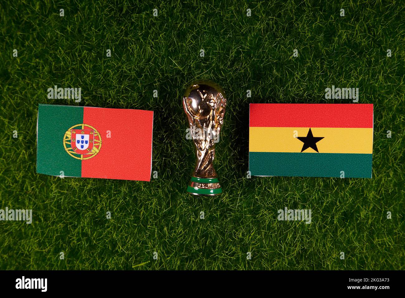 November 20, 2022, Doha, Qatar. Flags of Ghana and Portugal and the FIFA World Cup trophy on the green lawn of the stadium. Stock Photo