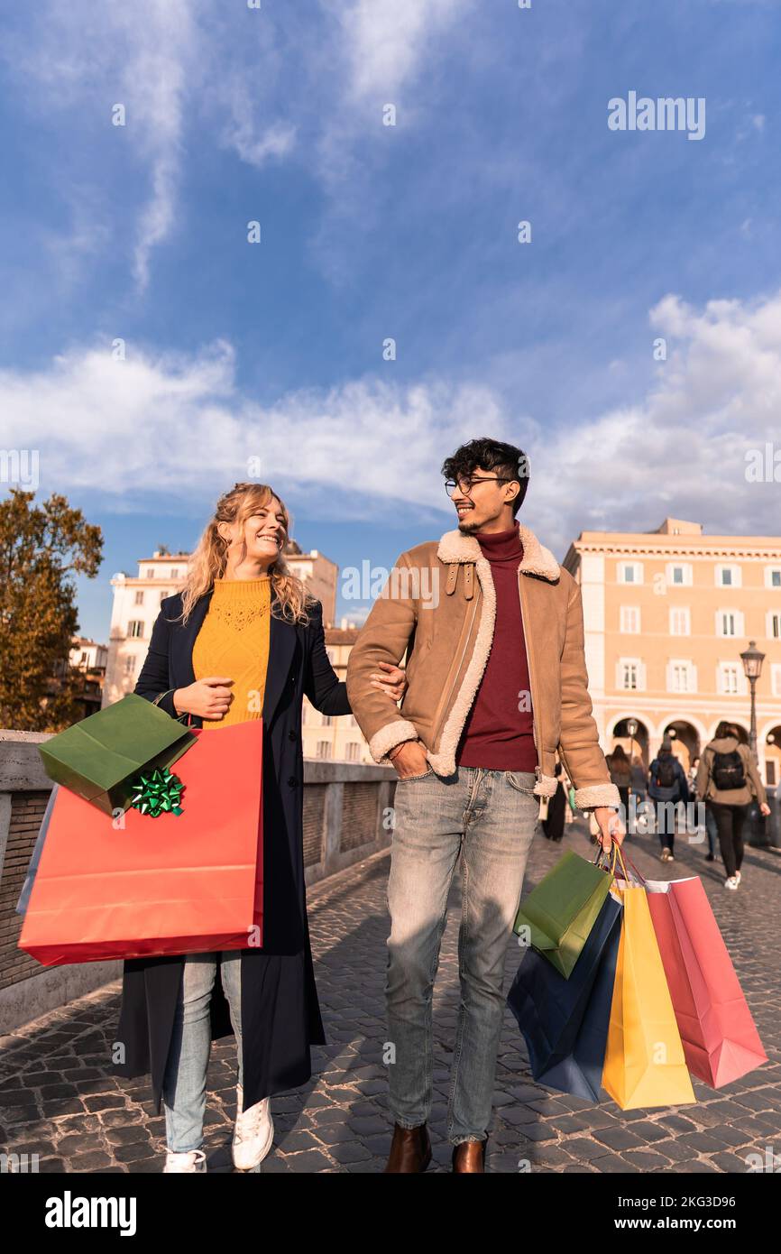 Young couple walking in the city with shopping bags, shopping time, autumn and winter season Stock Photo