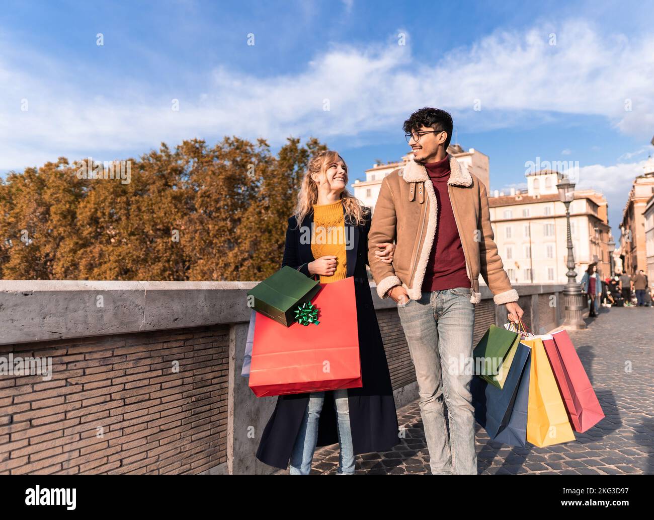 Young couple walking in town with shopping bags, shopping time, autumn and winter season Stock Photo