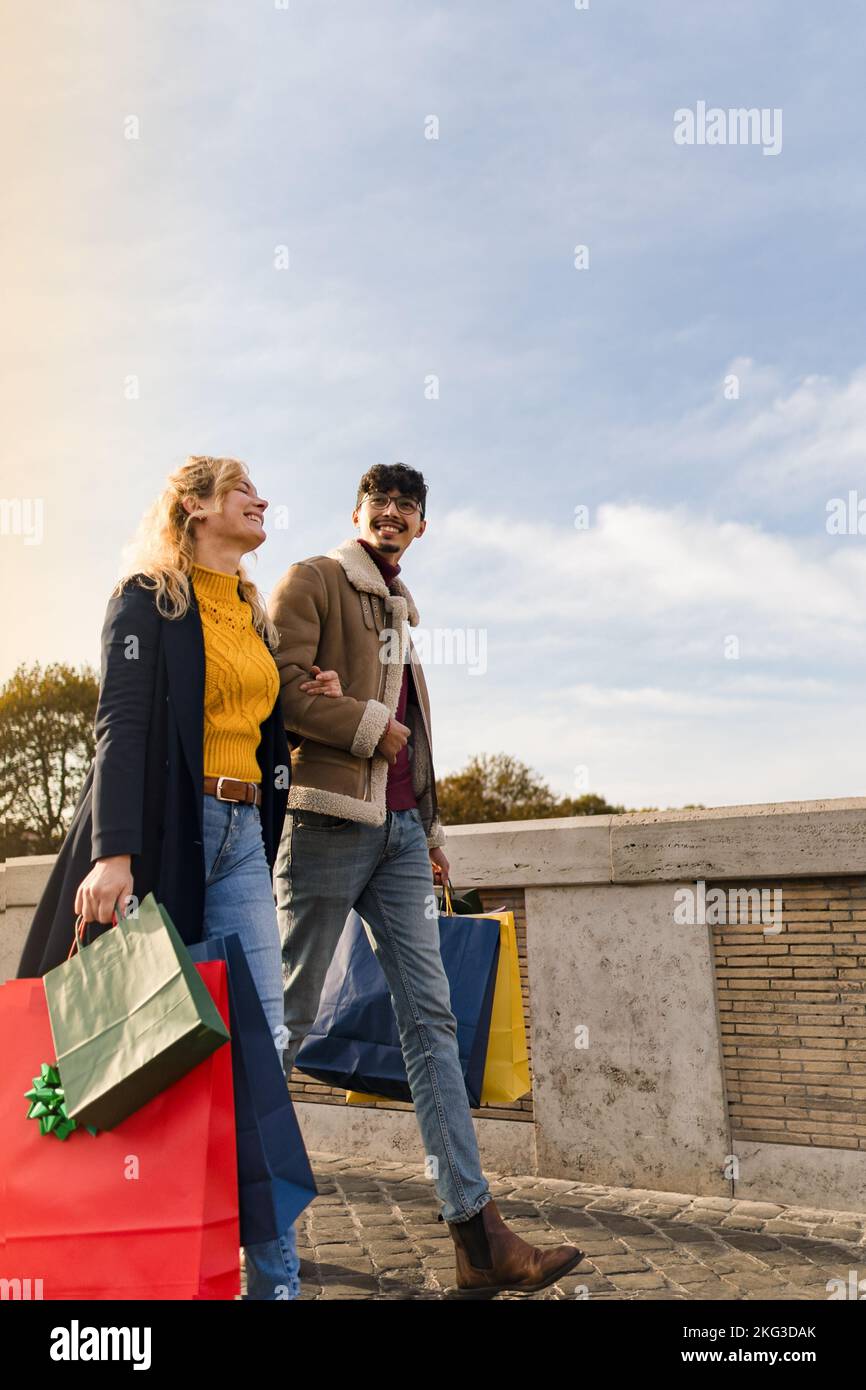 Young couple walking in town with shopping bags, shopping time, autumn and winter season Stock Photo