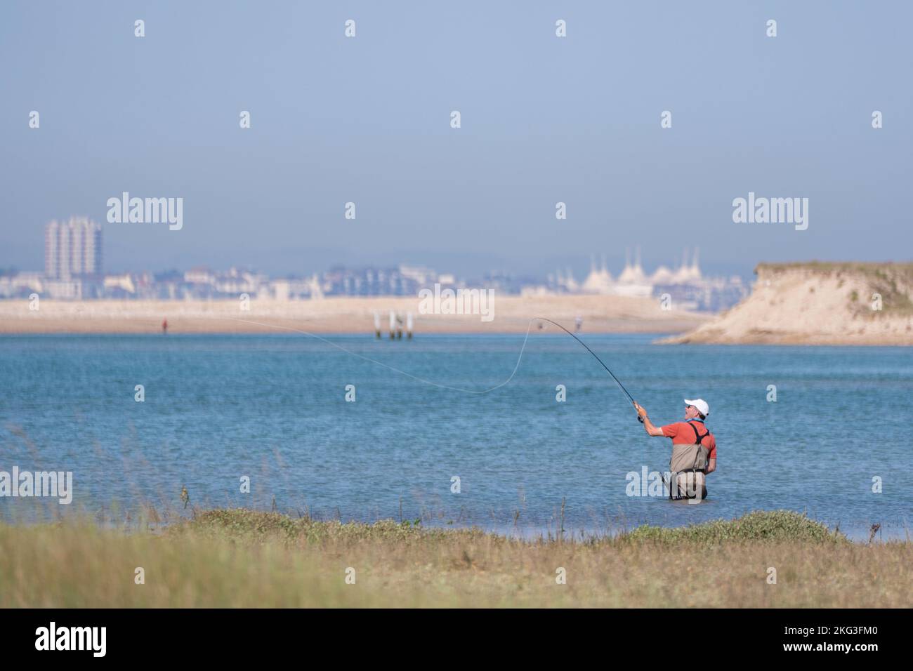 Flyfishing in the idyllic waters of Pagham Harbour in West Sussex with a backdrop of Bognor Regis. Stock Photo
