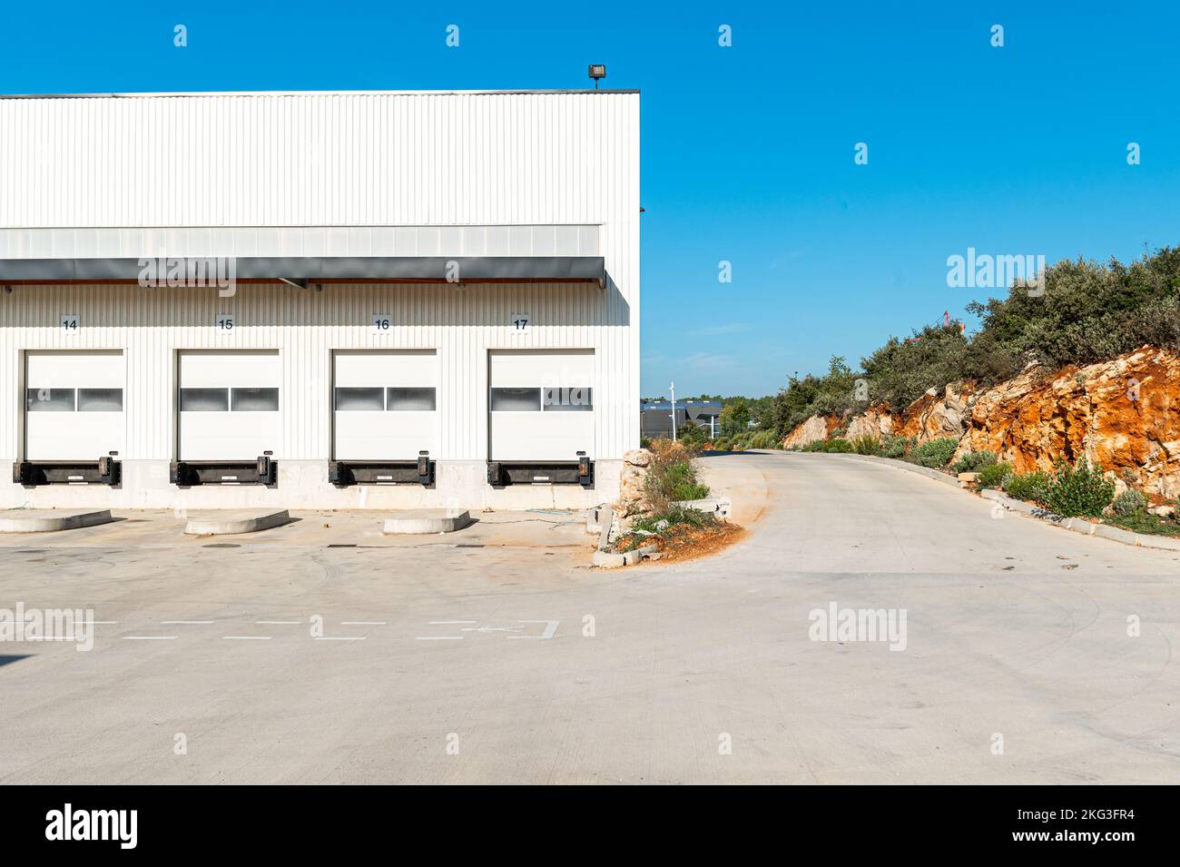 Facade shot of newly constructed logistic warehouse featuring empty loading docks in the Var, France Stock Photo