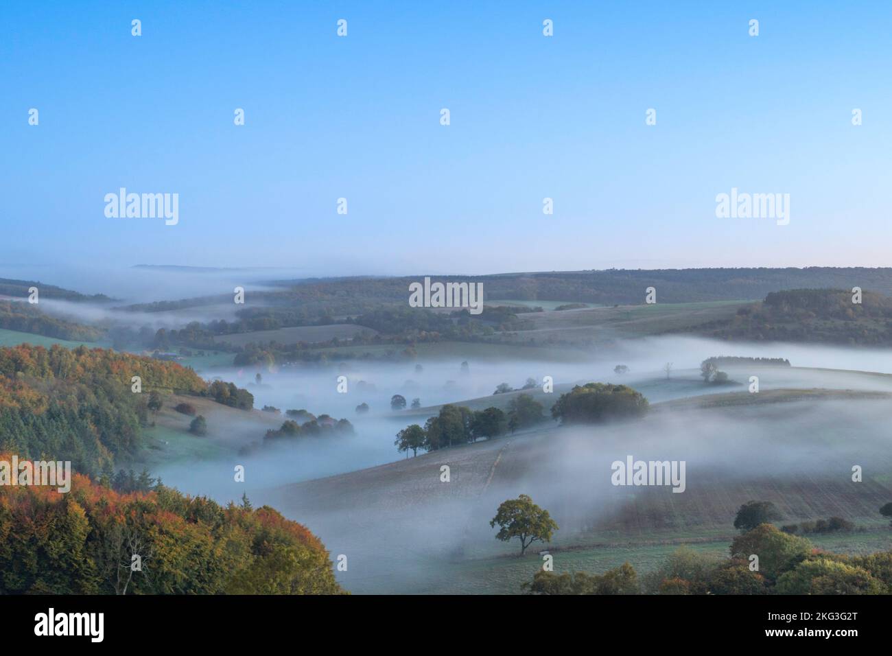 Early morning mist lying in the valley of Singleton in the South Downs National Park in the Autumn. Stock Photo