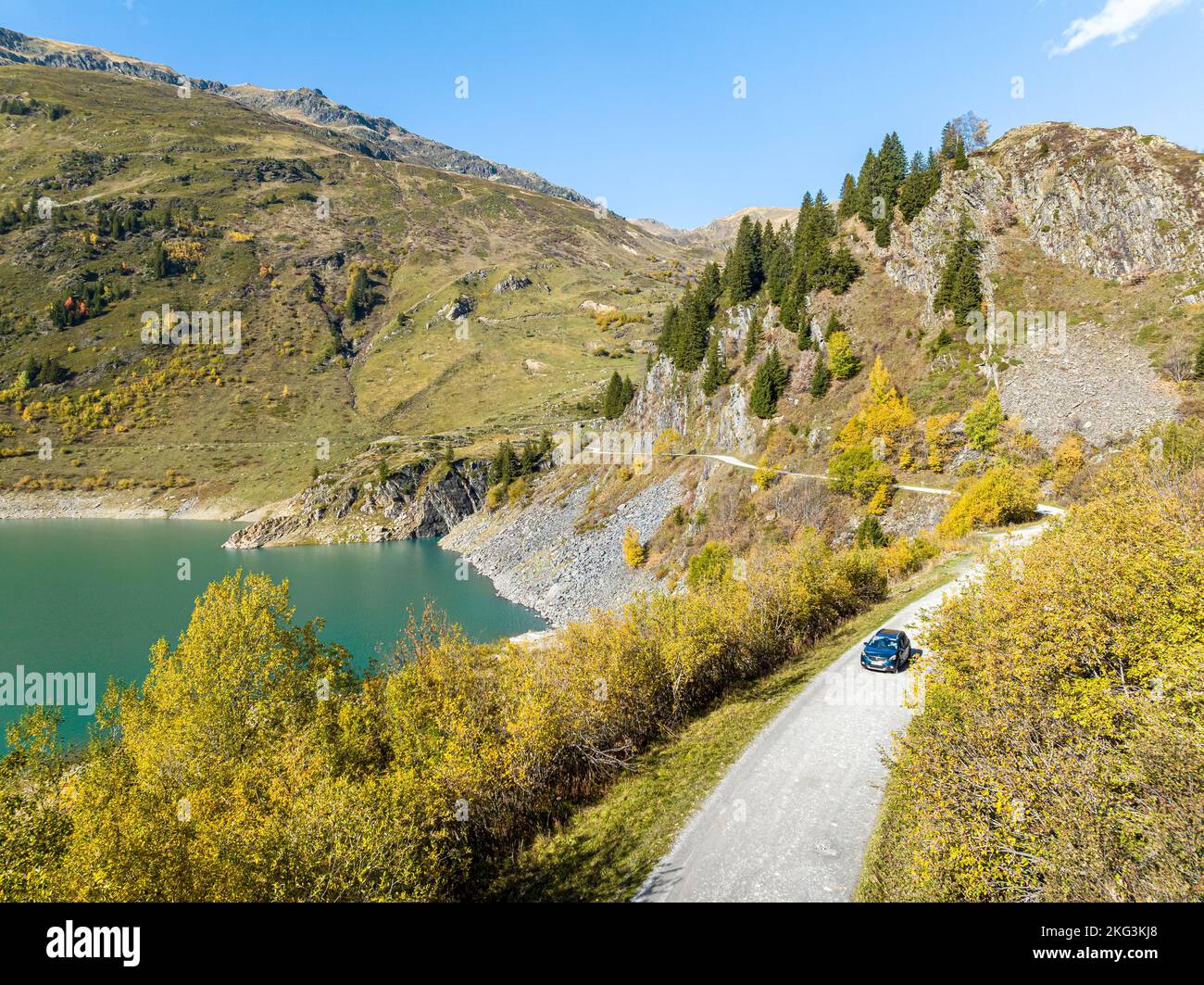 Drone shot of car passing by Beaufortain lake, a hidden destination in the alps of Savoie, France Stock Photo
