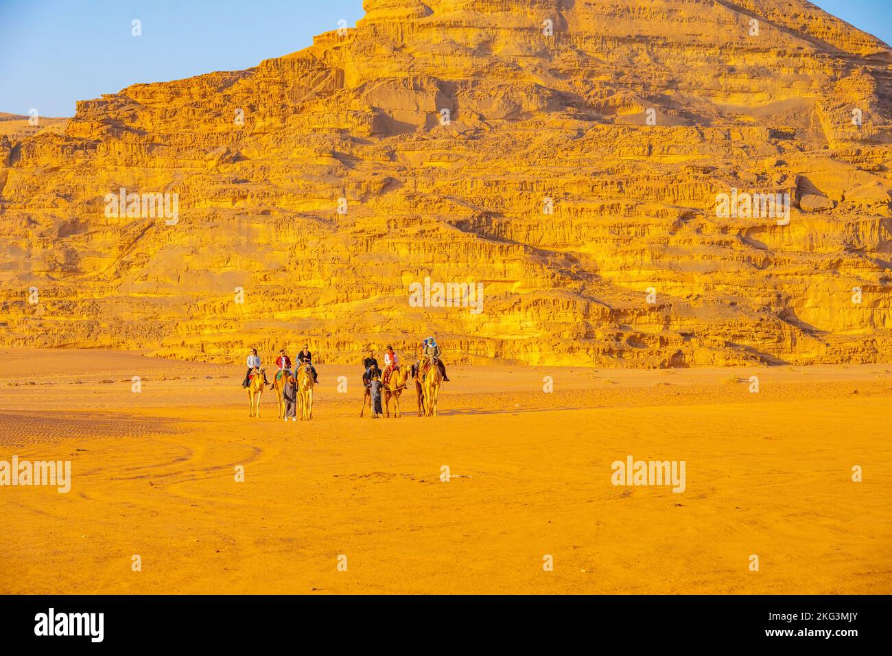 Tourists on an evening camel track on the sands of Wadi rum Jordan Stock Photo