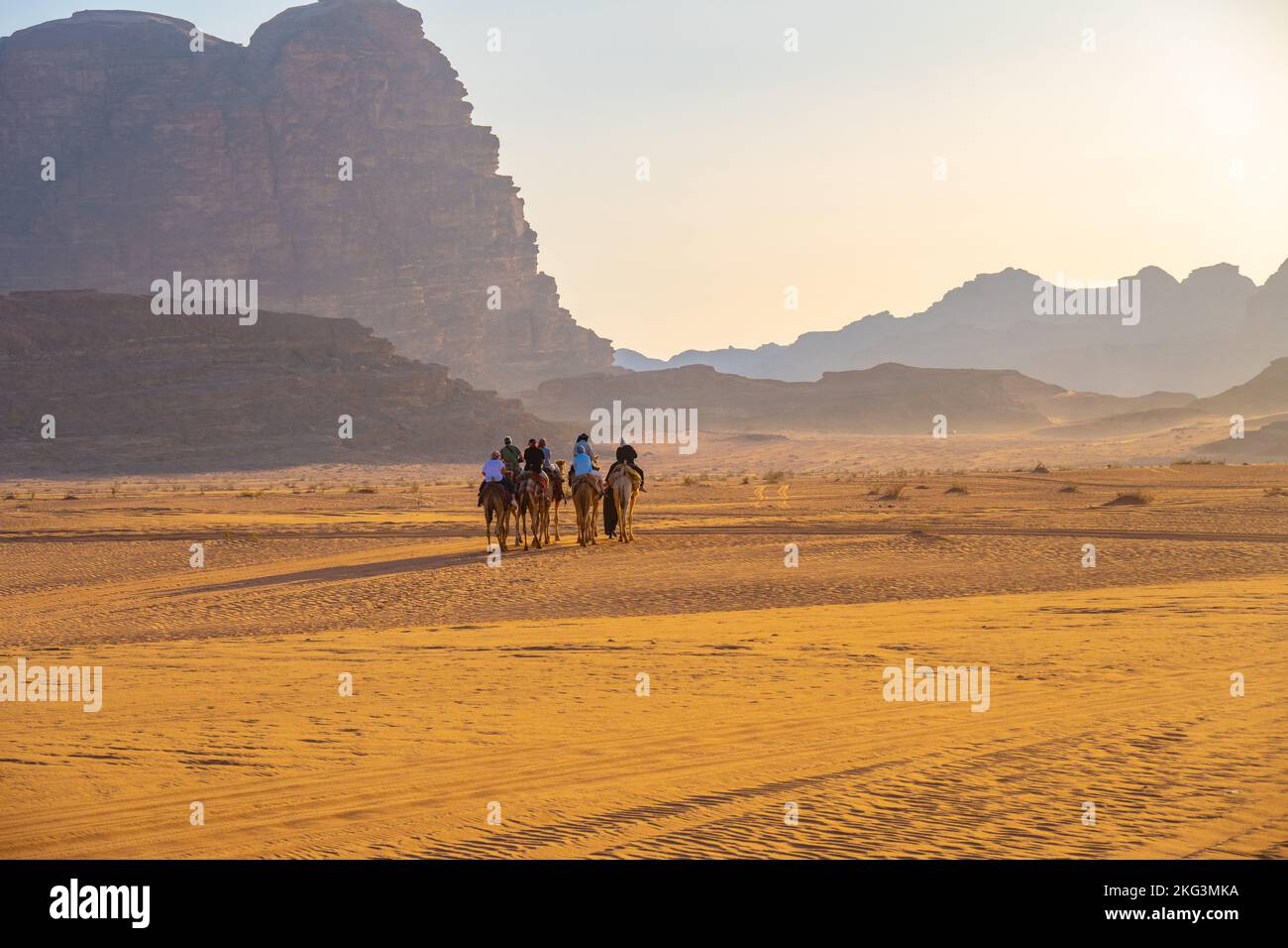 Tourists on an evening camel track on the sands of Wadi rum Jordan Stock Photo
