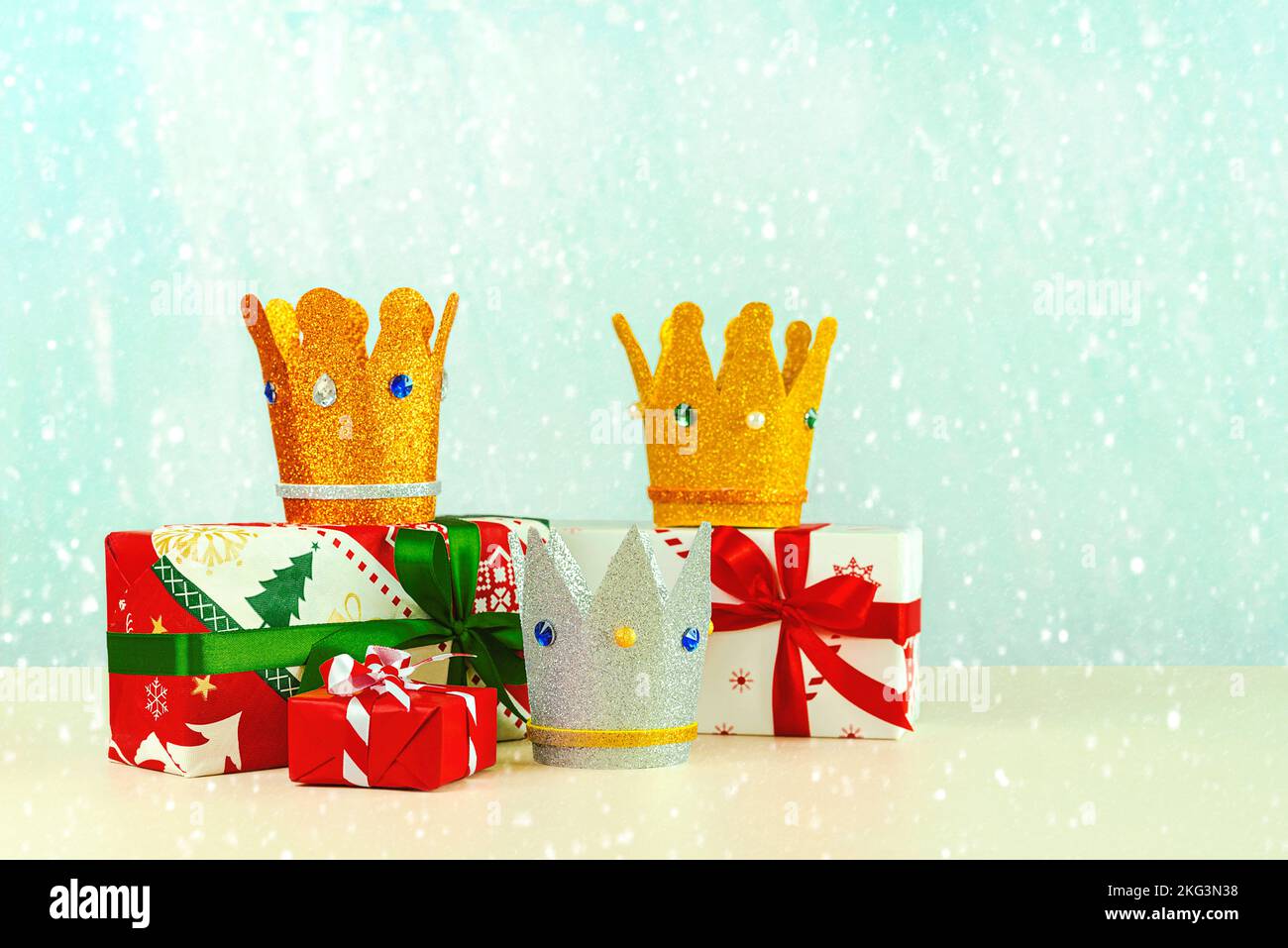 Three crowns of the three wise men with christmas gift boxes over blue background. Concept for Reyes Magos day. Three Wise Men Stock Photo