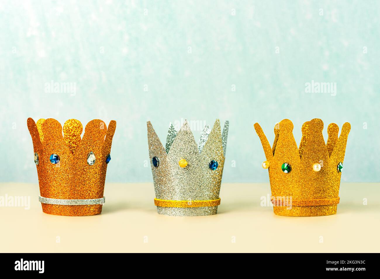 Three crowns of the three wise men with copy space over blue background. Concept for Reyes Magos day. Three Wise Men Stock Photo