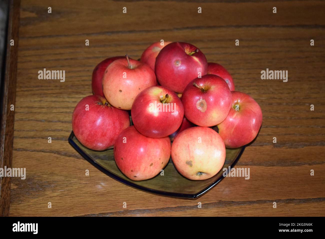 apples on a blue glass plate Stock Photo