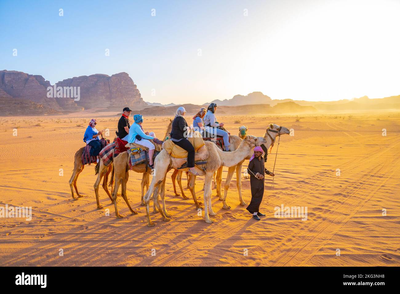 Tourists on an evening camel track on the sands of Wadi rum Jordan Stock Photo