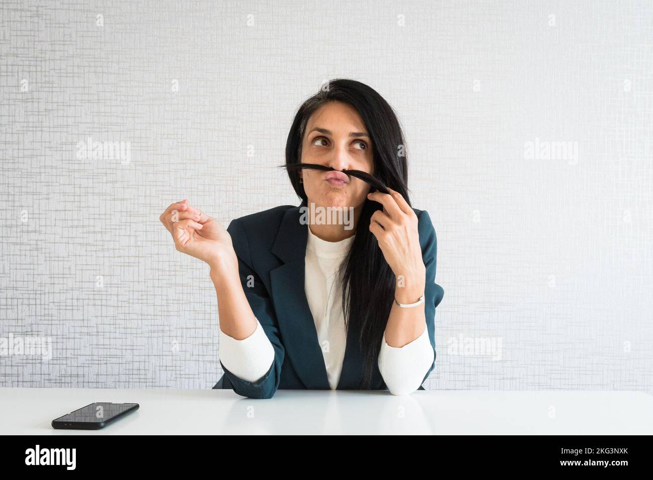 Young caucasian brunette business woman director in office play hair make fish face. Bored Business Woman Spending Time at the Office. Lazy corporate Stock Photo