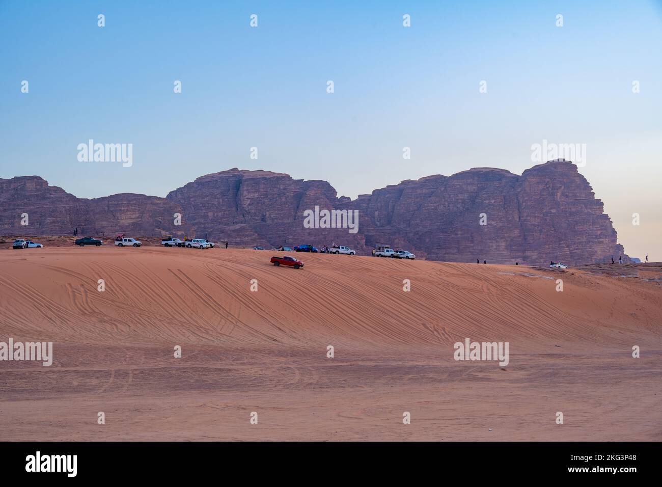 4x4 vehicles on a sand dune in Wadi Rum watching the sunset. Stock Photo