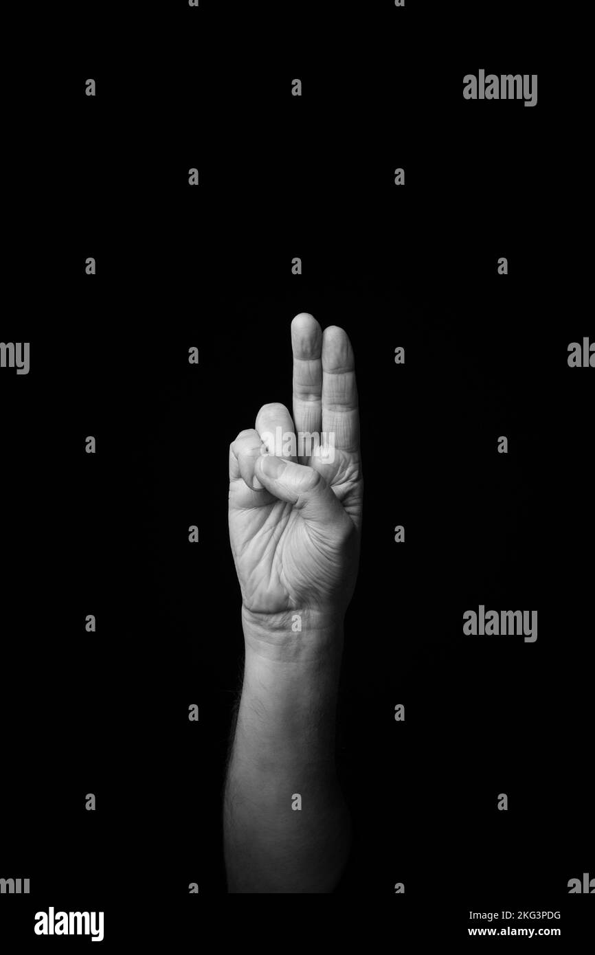 Dramatic black and white image of a male hand fingerspelling the Fench ...