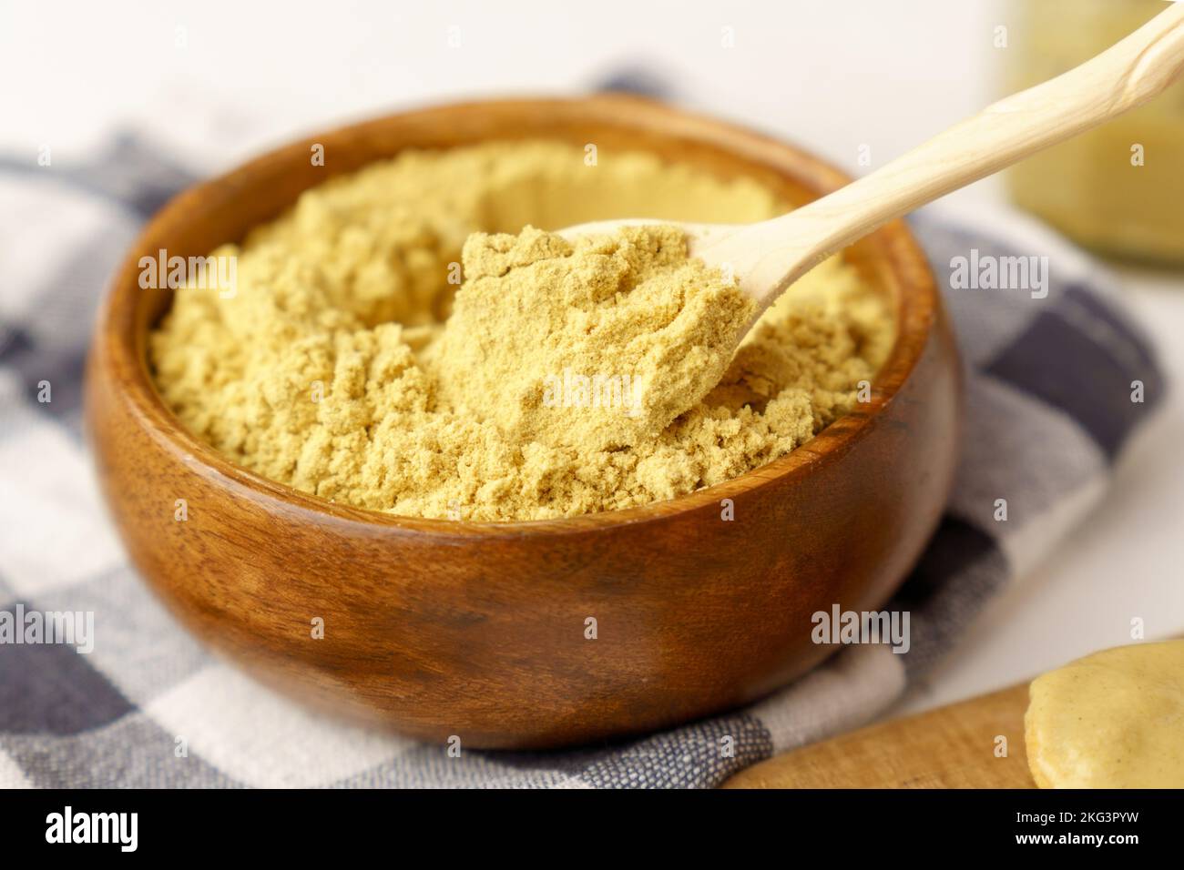 Mustard powder in wooden bowl. Mustards are plants of the genera ...