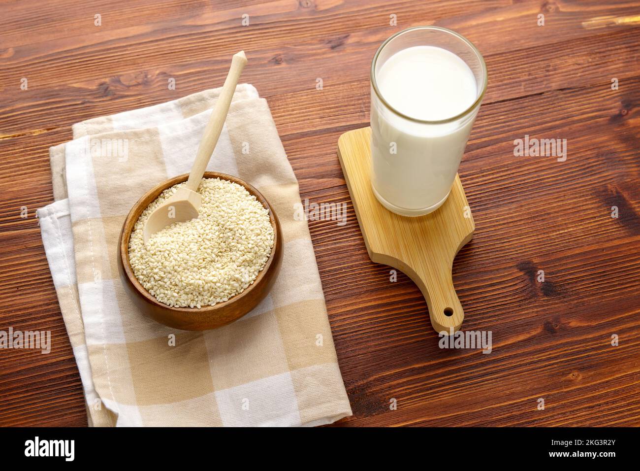 Sesame seed milk in a glass. White sesame seeds on a table. Dairy